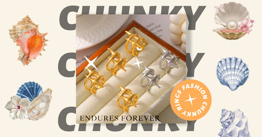 Close-up of three ENDURES FOREVER chunky gold rings on a hand with nude nails. The sleek, fluid designs showcase how to incorporate statement rings into 2025’s minimalist everyday style. Grey fabric background emphasizes versatility.