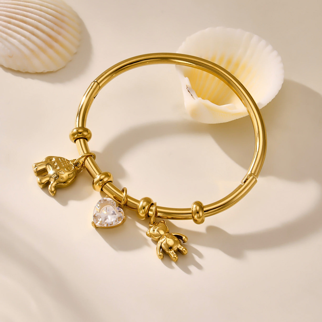 Waterproof gold charm bracelet in stainless steel on beige fabric background