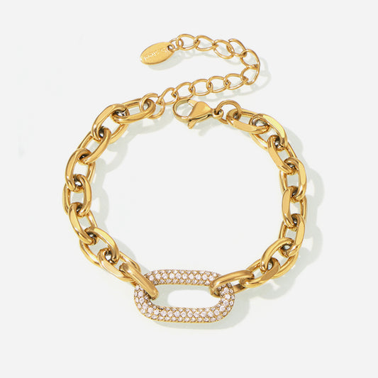 A gold-colored stainless steel anchor link bracelet with a square-shaped CZ pendant.