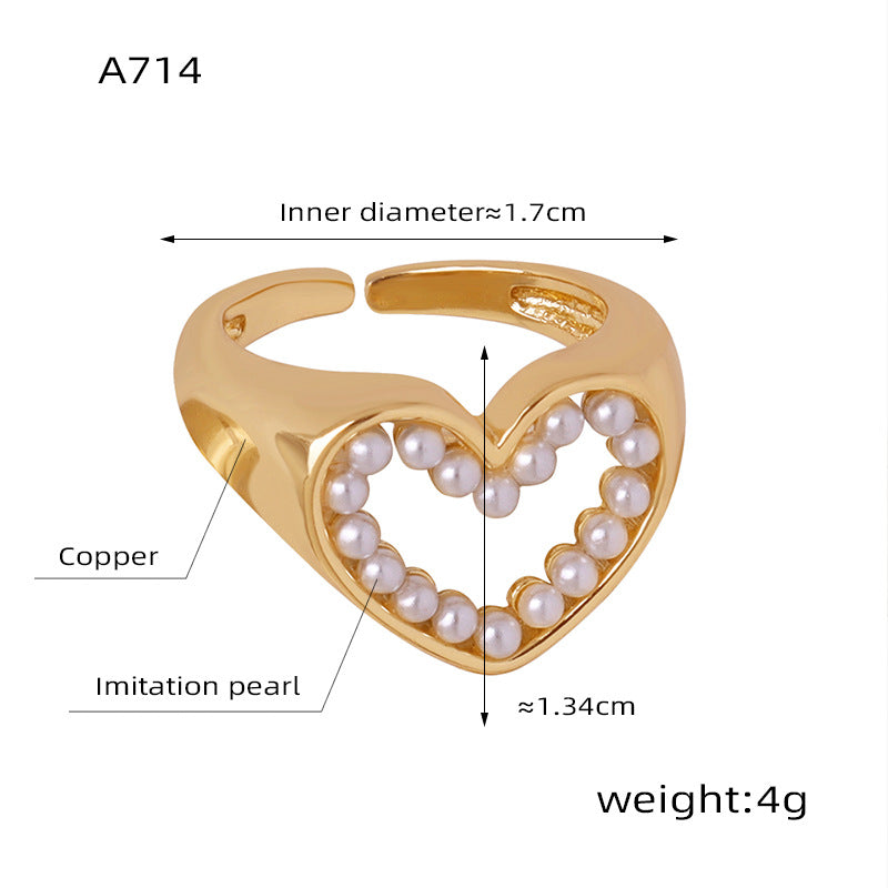 Gold heart-shaped ring with imitation pearls and technical details on a white background