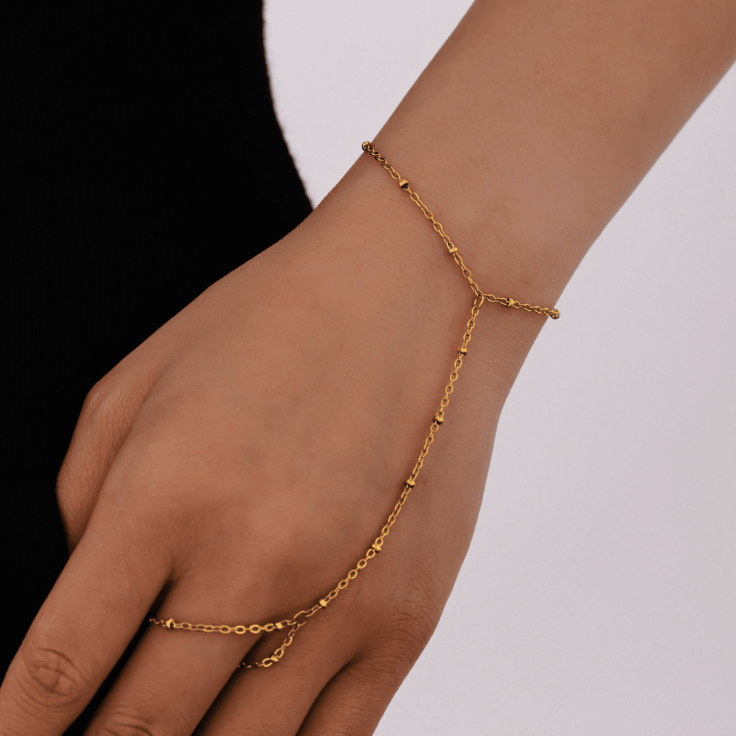 Waterproof gold bead bracelet resting on linen with sunlight – asymmetrical tennis bracelet design