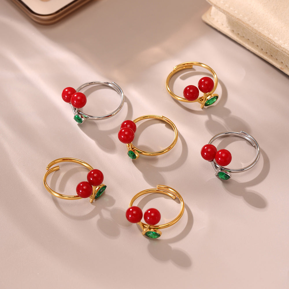 Mixed metal berry-inspired sea glass rings with red resin on beige