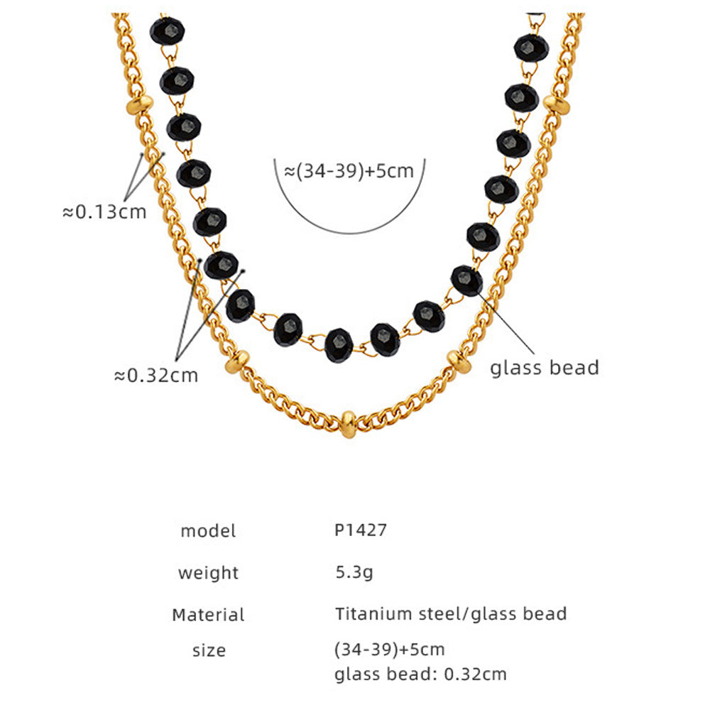 Close-up of model holding black sea glass necklace with size chart
