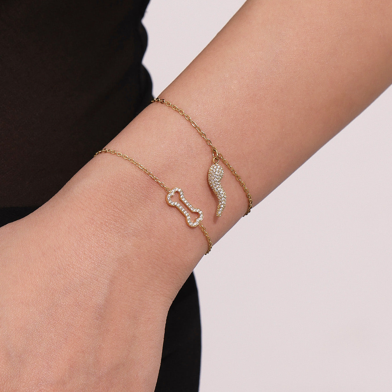 Gold bracelet with a unique design on a wrist against a neutral background
