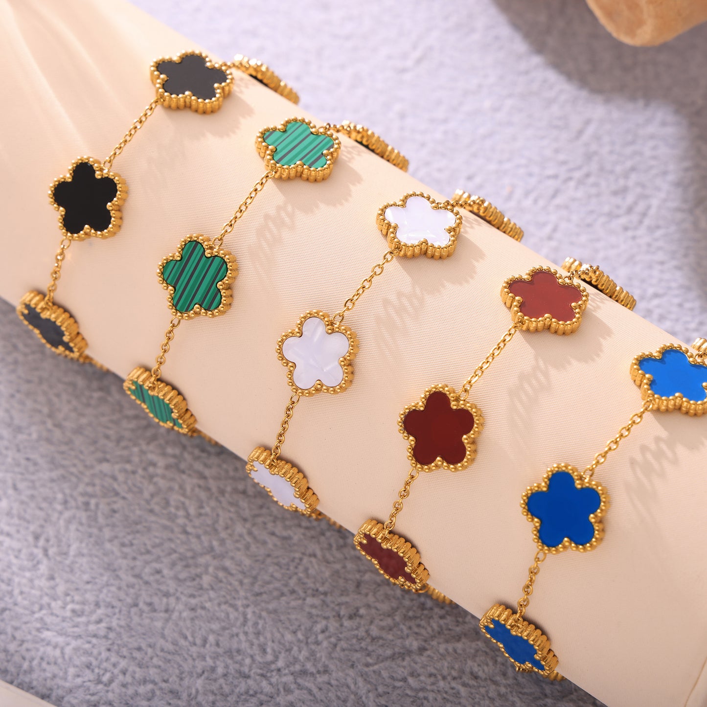 Five stainless steel beaded bracelets with colorful stones in natural lifestyle scene, laid out decoratively