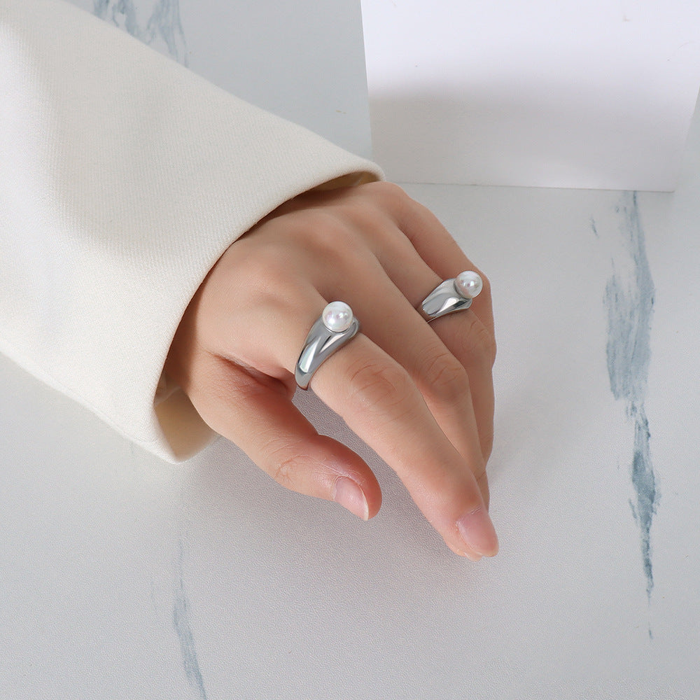 Close-up of hand wearing silver imitation pearl rings – minimalist adjustable fashion jewelry