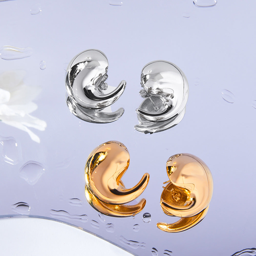 Pair of gold and silver earrings on a light purple background