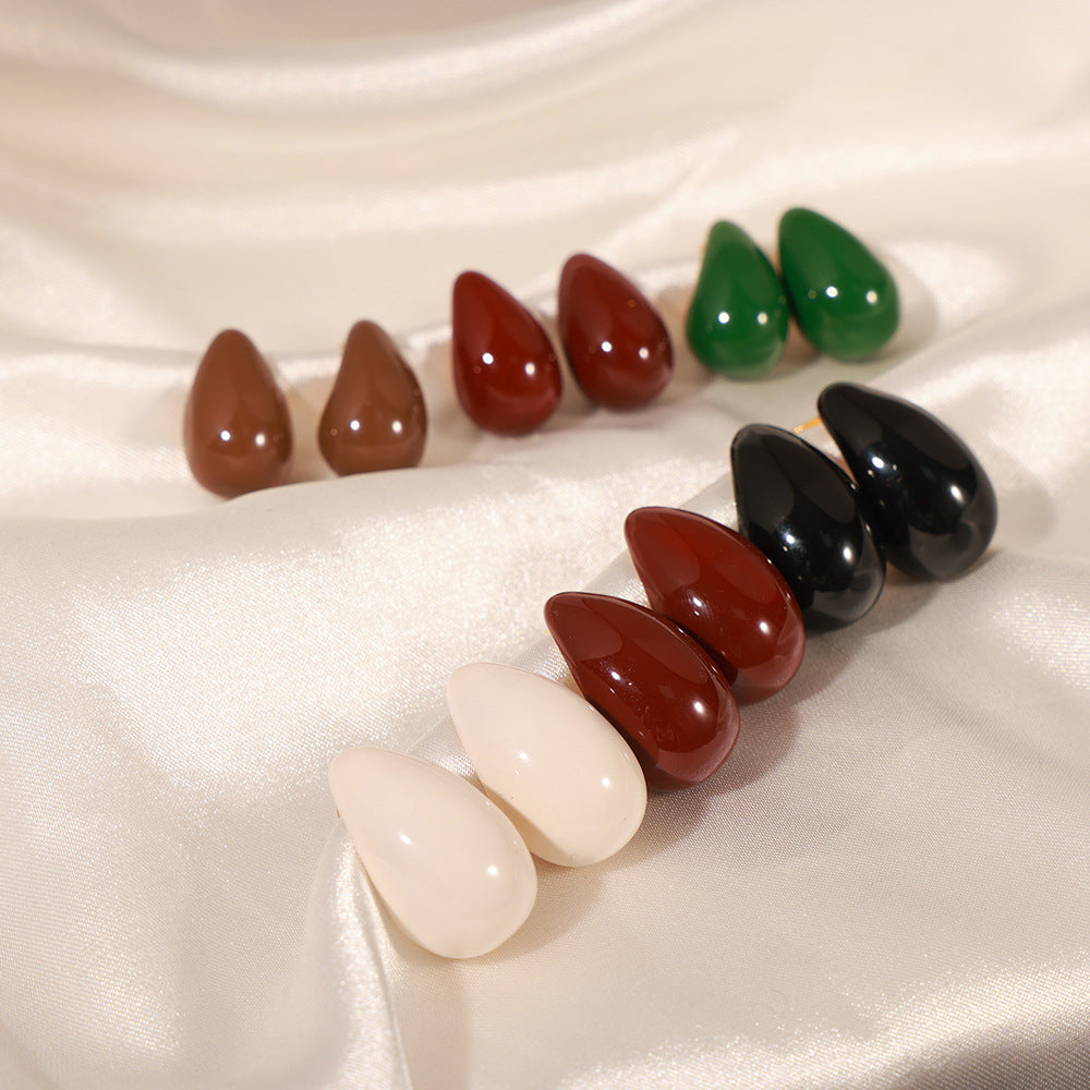 Set of colorful teardrop-shaped stones on a satin surface