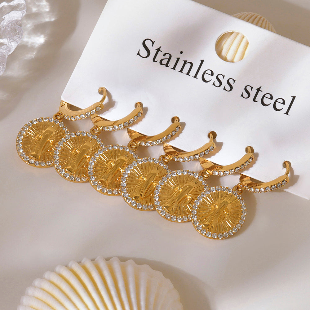 Gold earrings with circular designs on a white background with 'Stainless steel' text.