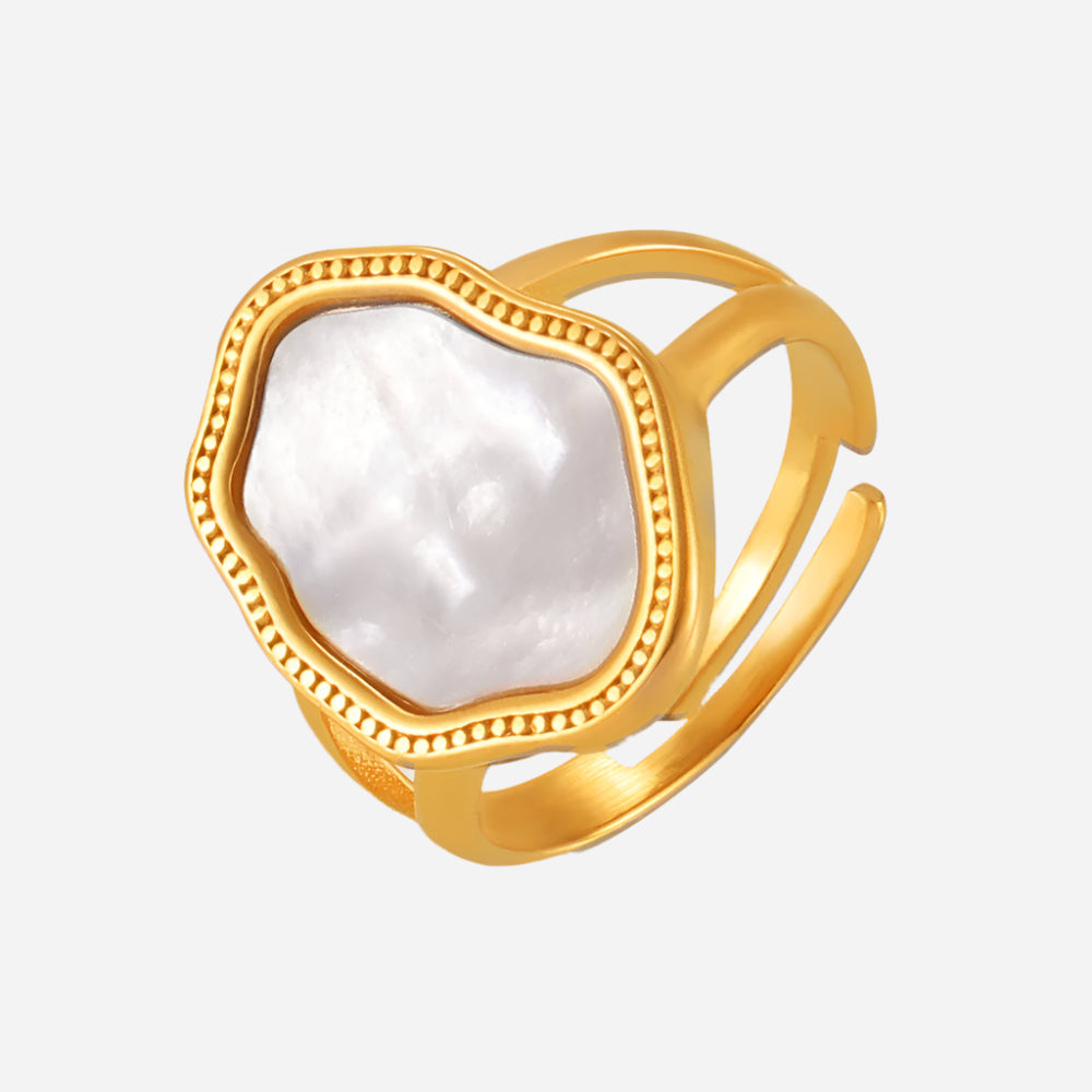 Gold-plated mother of pearl ring on light gray background – minimalist seashell design