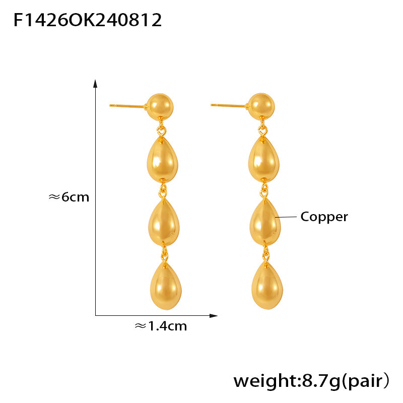 Gold teardrop-shaped earrings with measurements and material label on a white background