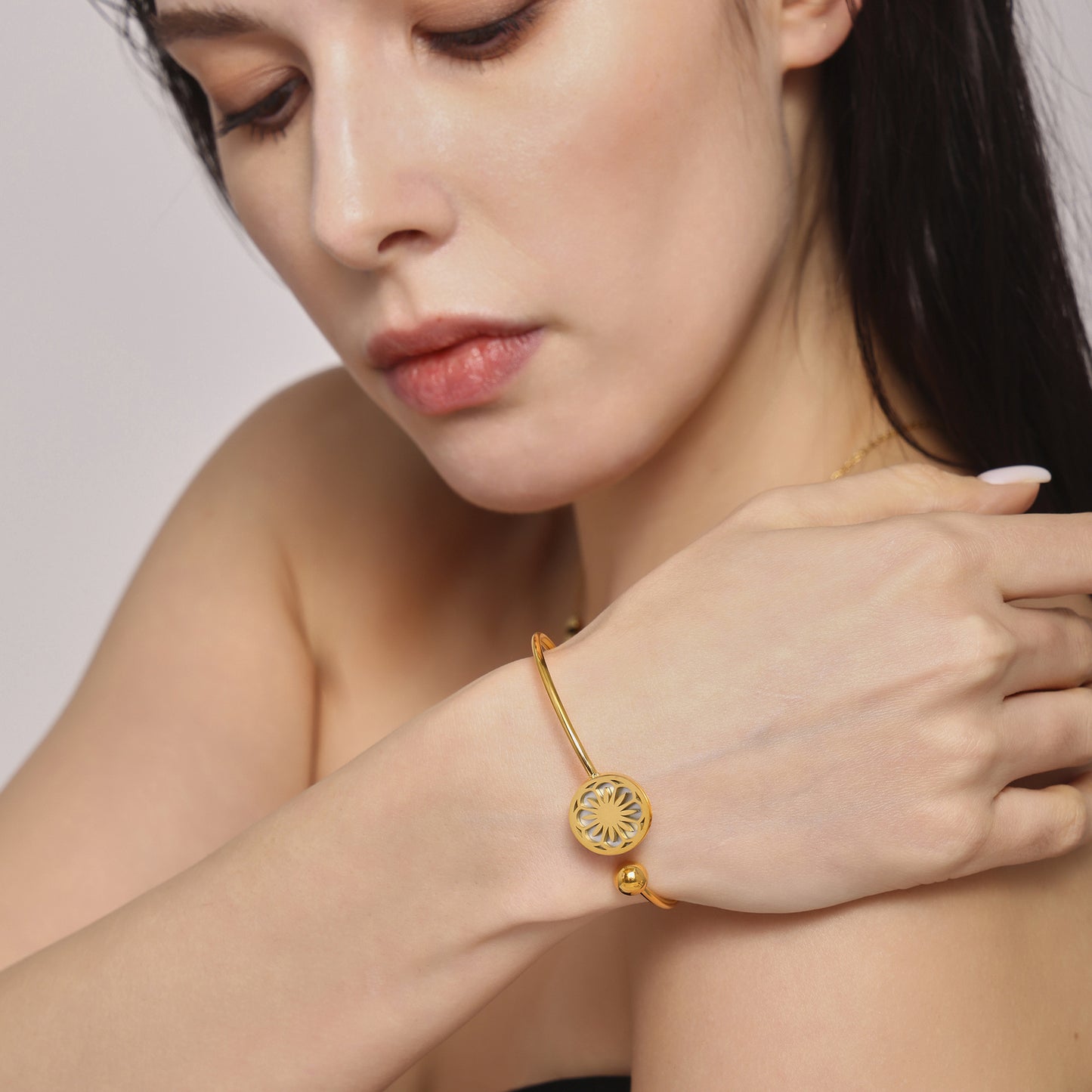 Woman’s wrist adorned with detailed gold bracelet – stylish adjustable jewelry