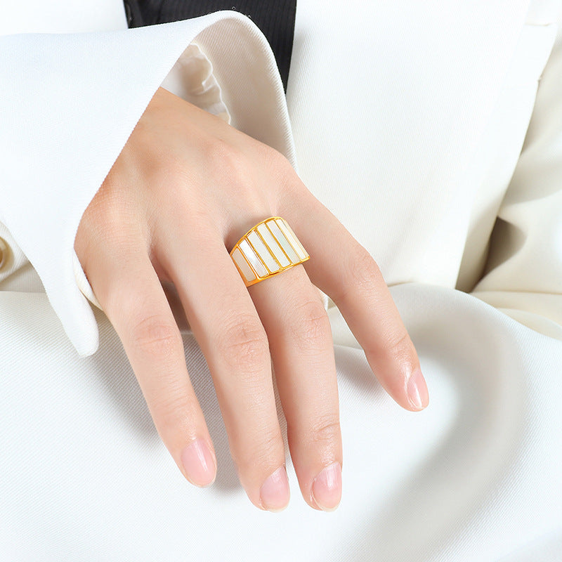 Hand wearing adjustable gold ring with striped design on white background – elegant stacking ring
