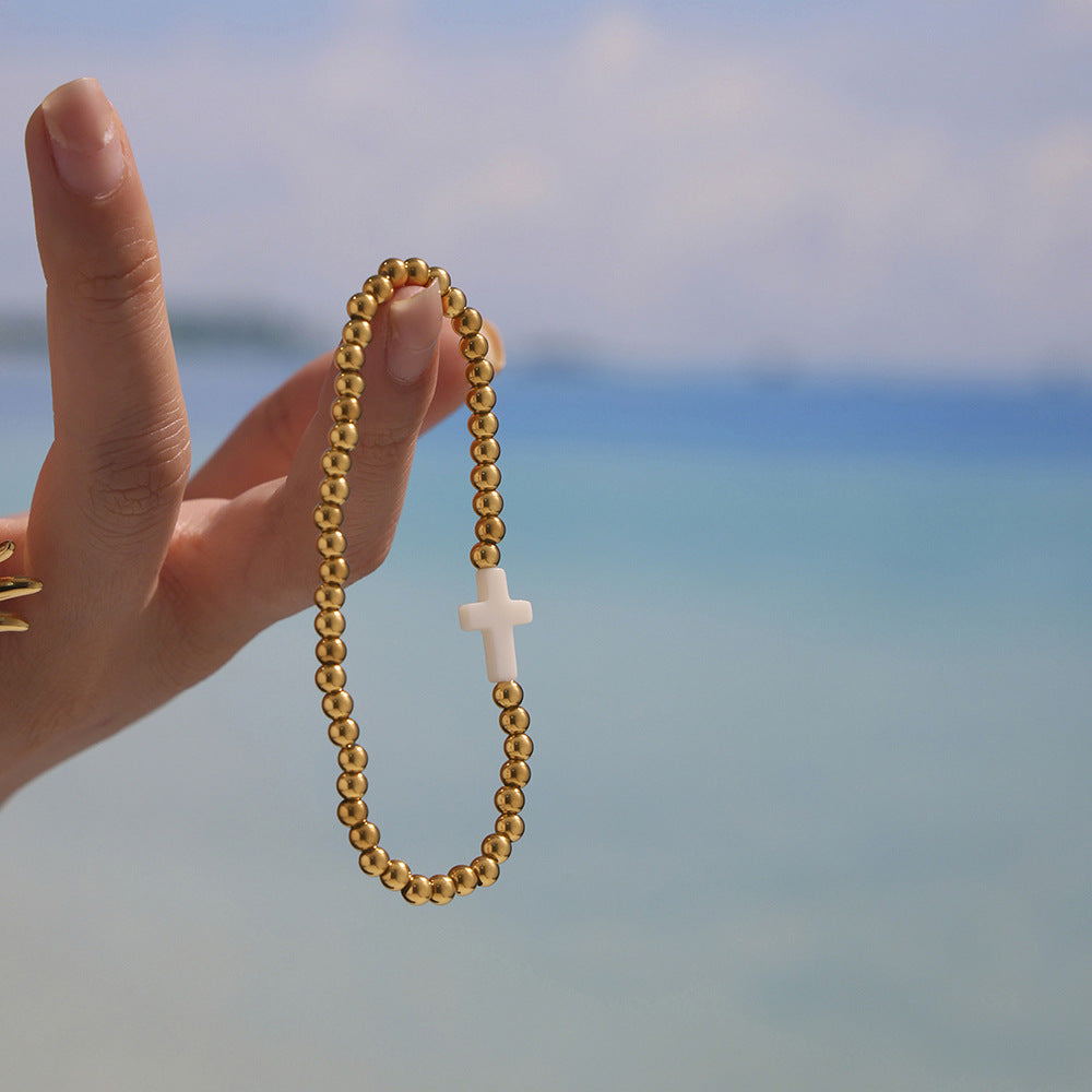 Model Holding Cross Charm Shell Beaded Bracelet – Gold Waterproof Design