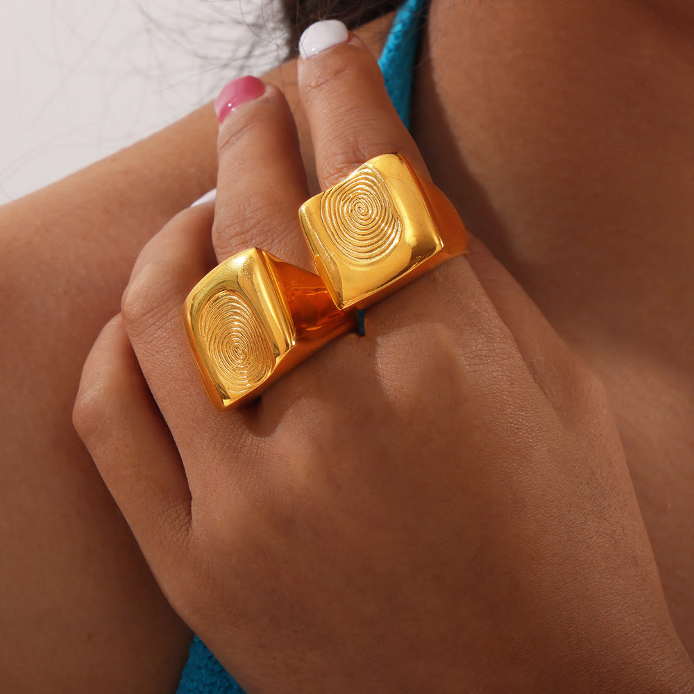 Close-up of hand wearing adjustable gold rings with engraved design – minimalist jewelry