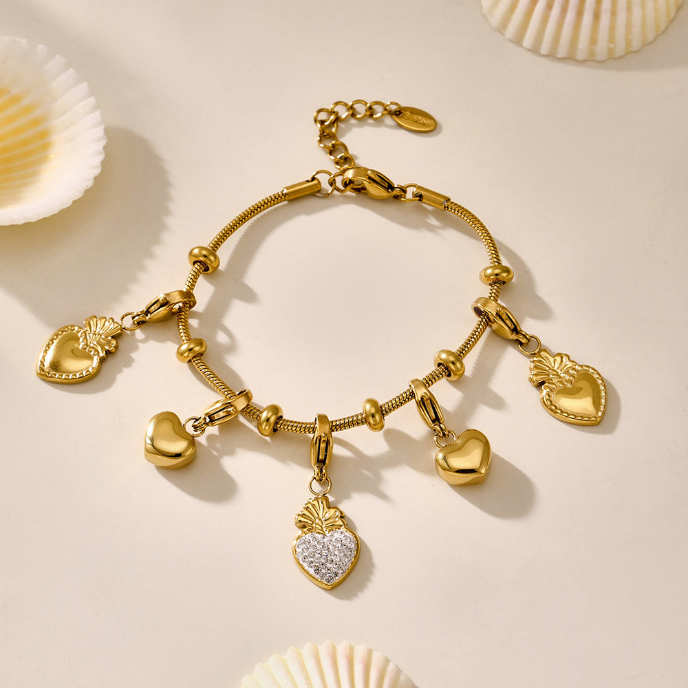 DIY gold bracelet with heart-shaped charms made from hypoallergenic stainless steel, styled on a beige background.