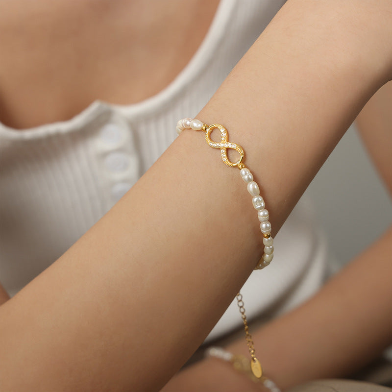 Model wearing waterproof infinity gold pearl bracelet, close-up on wrist
