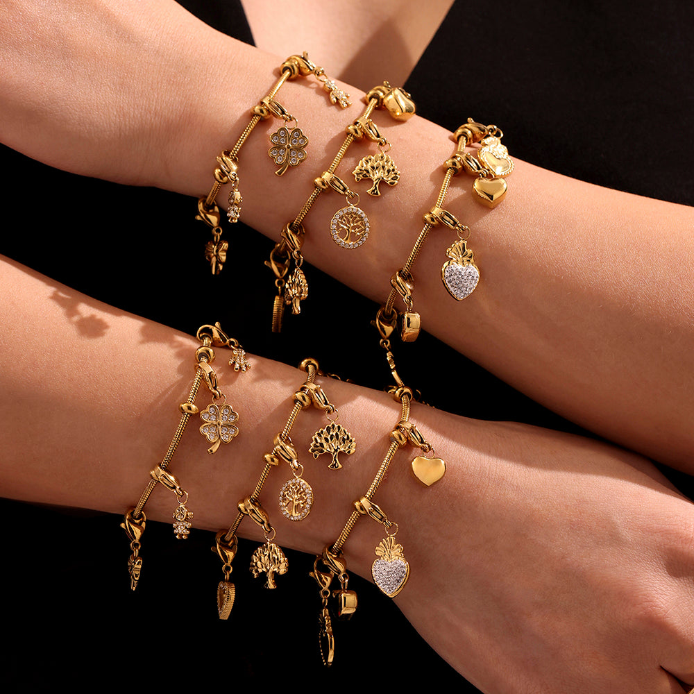Multiple gold charm bracelets from DIY kit shown on a black background, featuring stainless steel construction and unique charms.