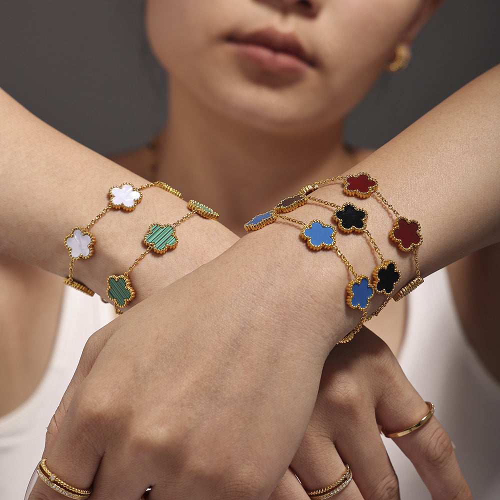 Model crossing hands wearing multiple agate beaded bracelets: black, blue, red on left; white and blue on right