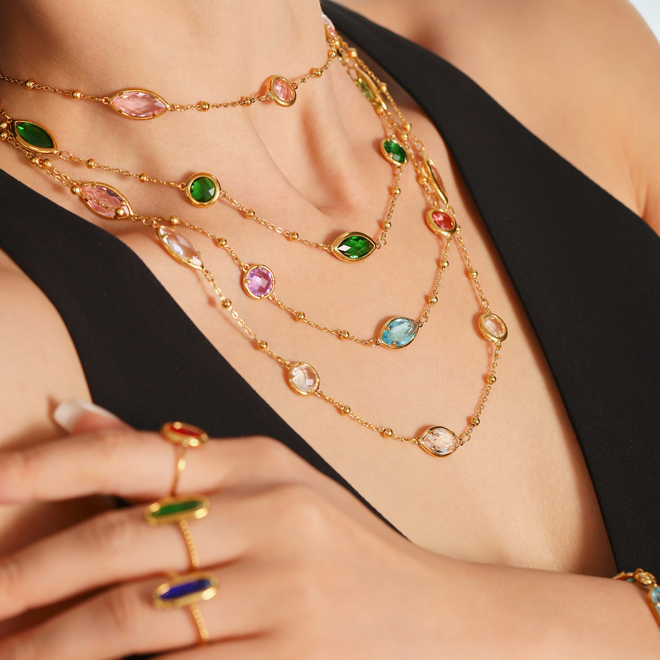 Layered red, green, blue, and white sea glass necklaces worn on model neck