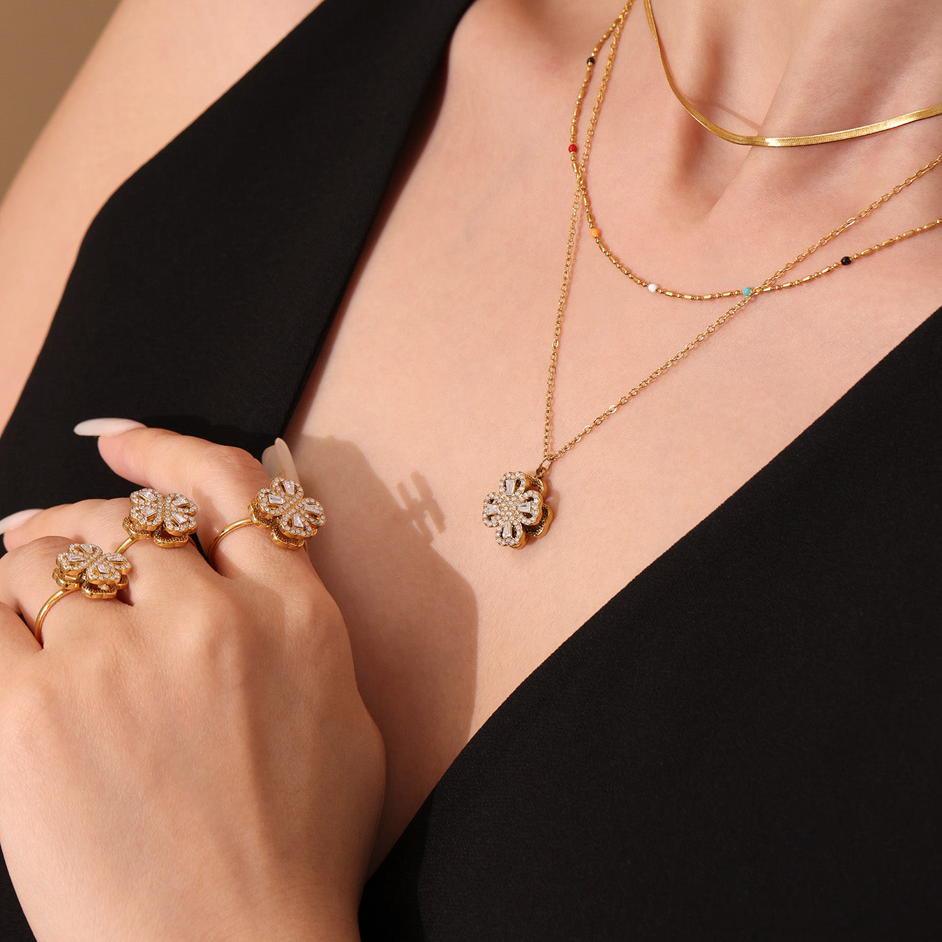 Model wearing rotating flower necklace with matching gold zirconia ring