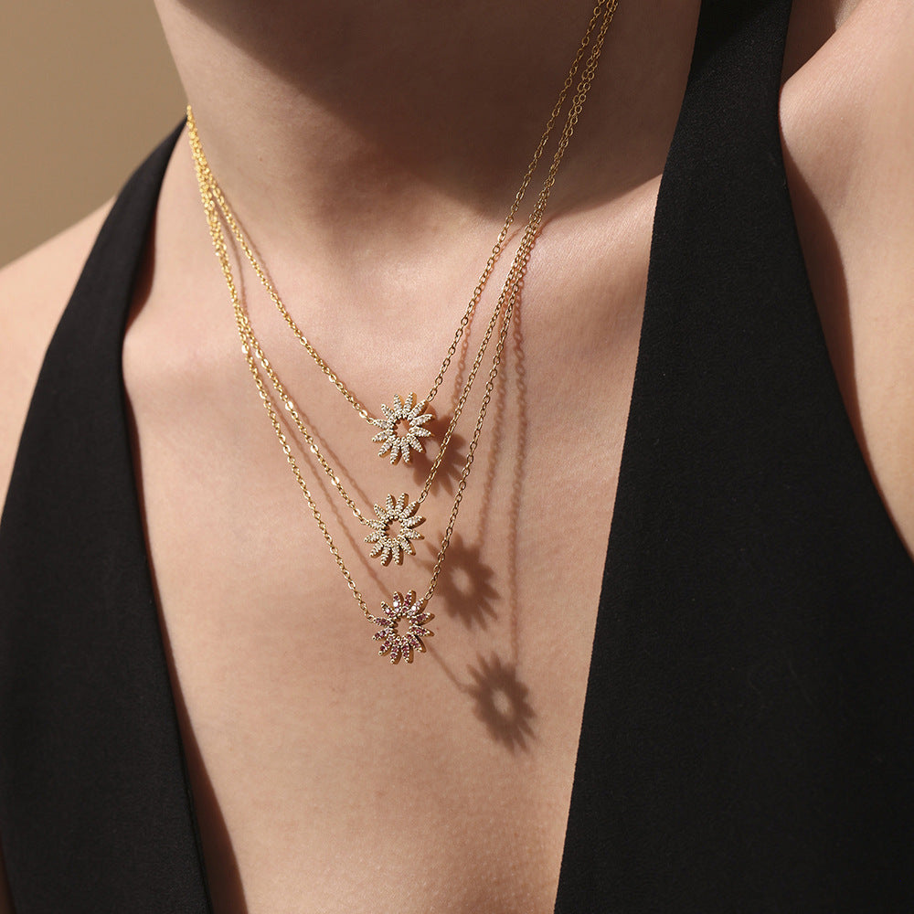 Model wearing dainty gold necklace with white zirconia sunflower charm
