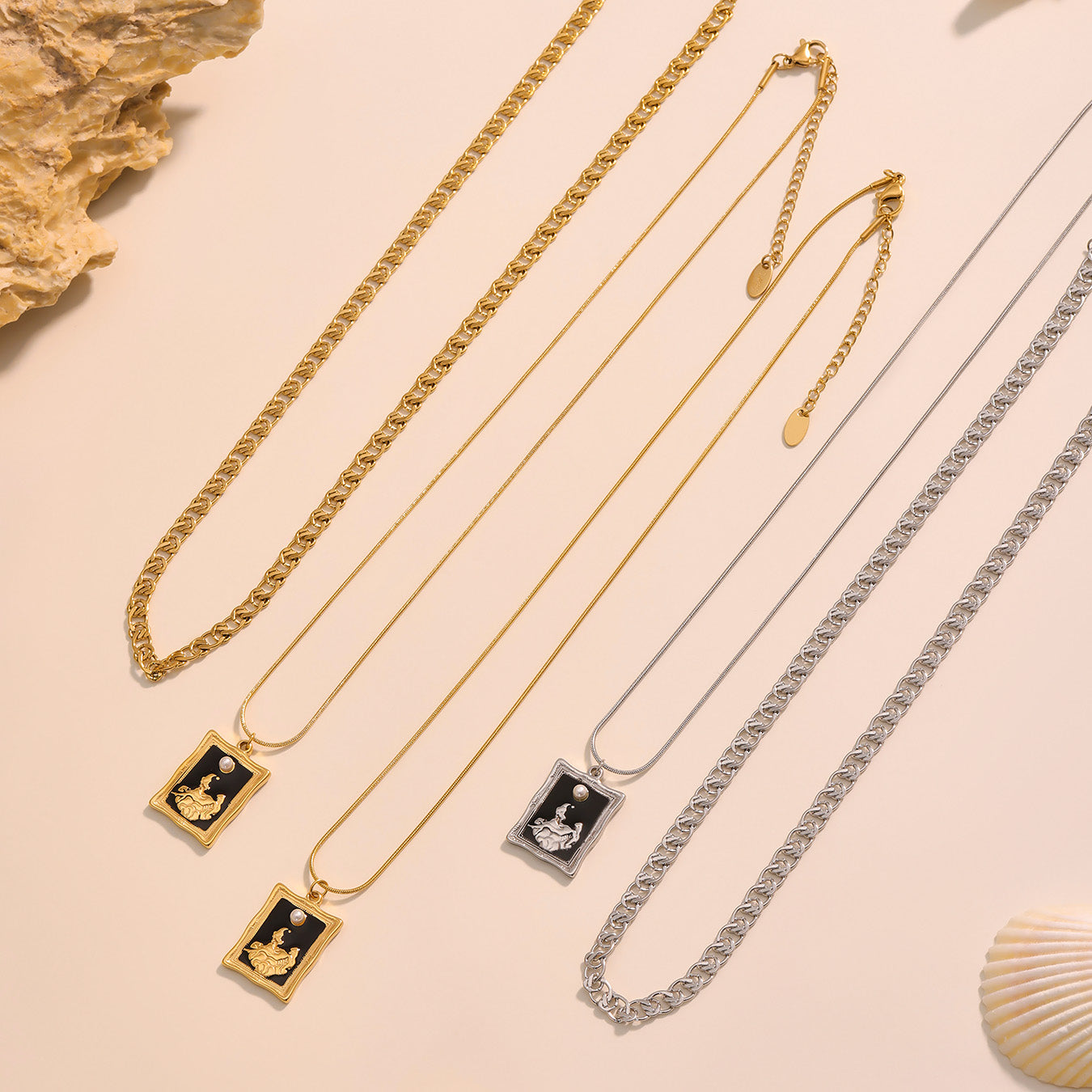 Gold and silver necklaces with pendants on a beige background
