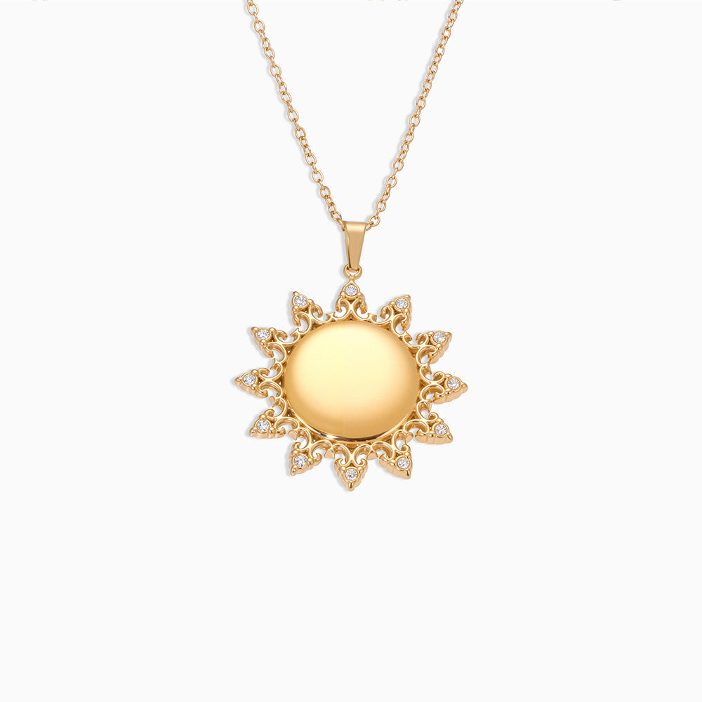 Gold sun-shaped pendant necklace on a white background