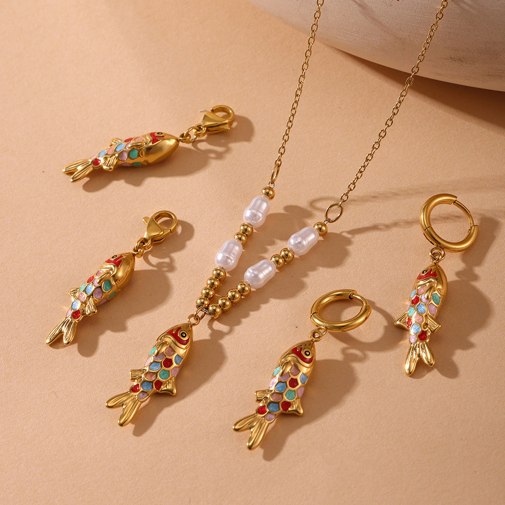 Gold necklace with fish-shaped pendants on a beige background
