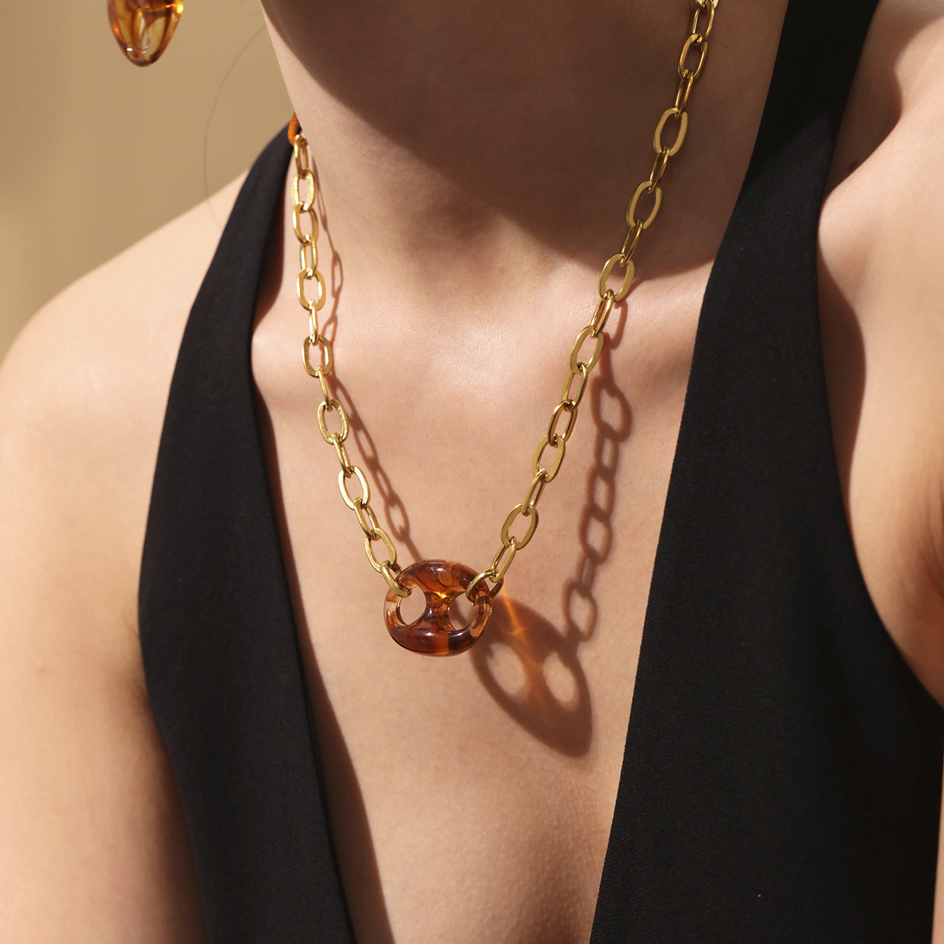 Colorful chunky resin necklace styled with layered chokers and beachwear