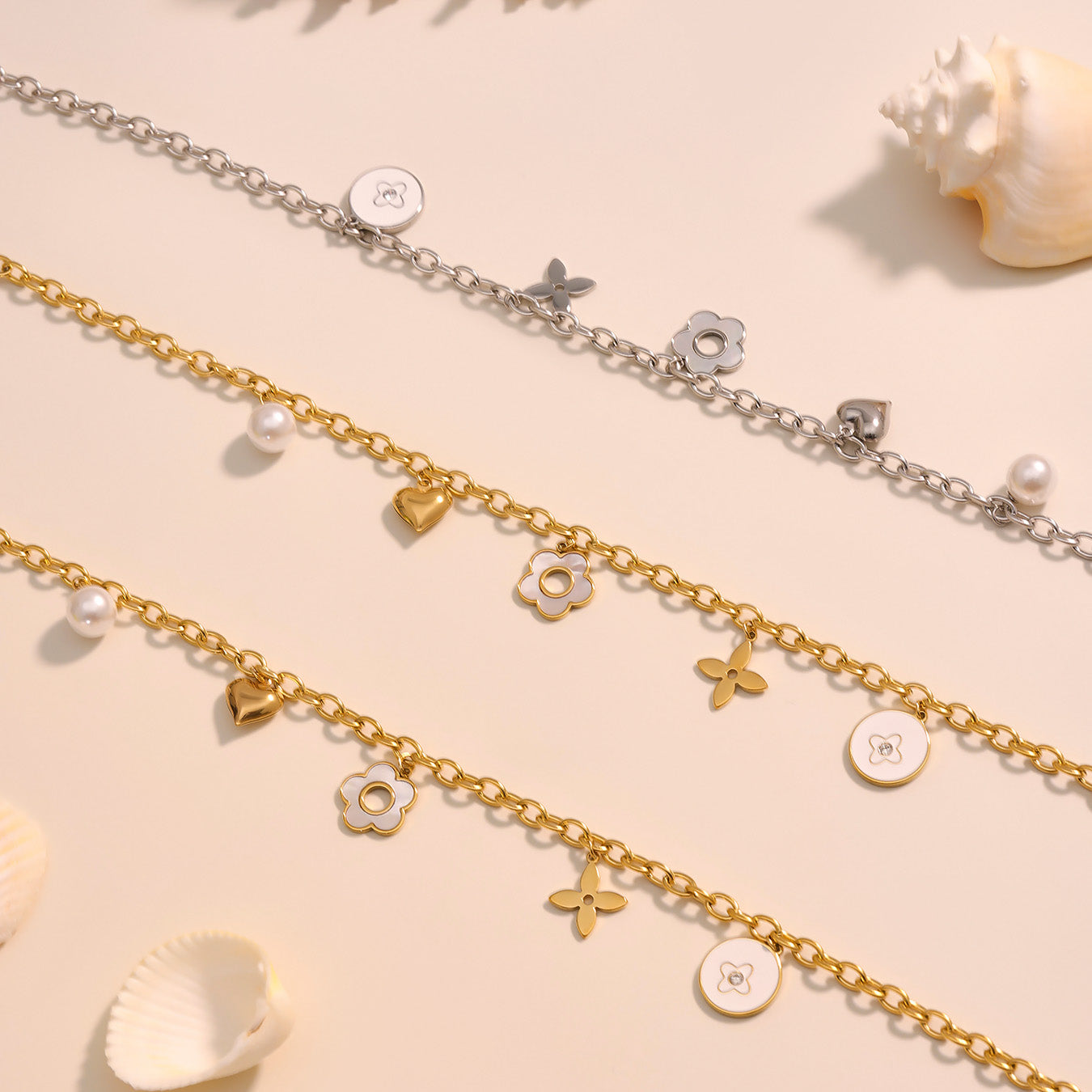 Three gold and silver chains with various charms on a beige background