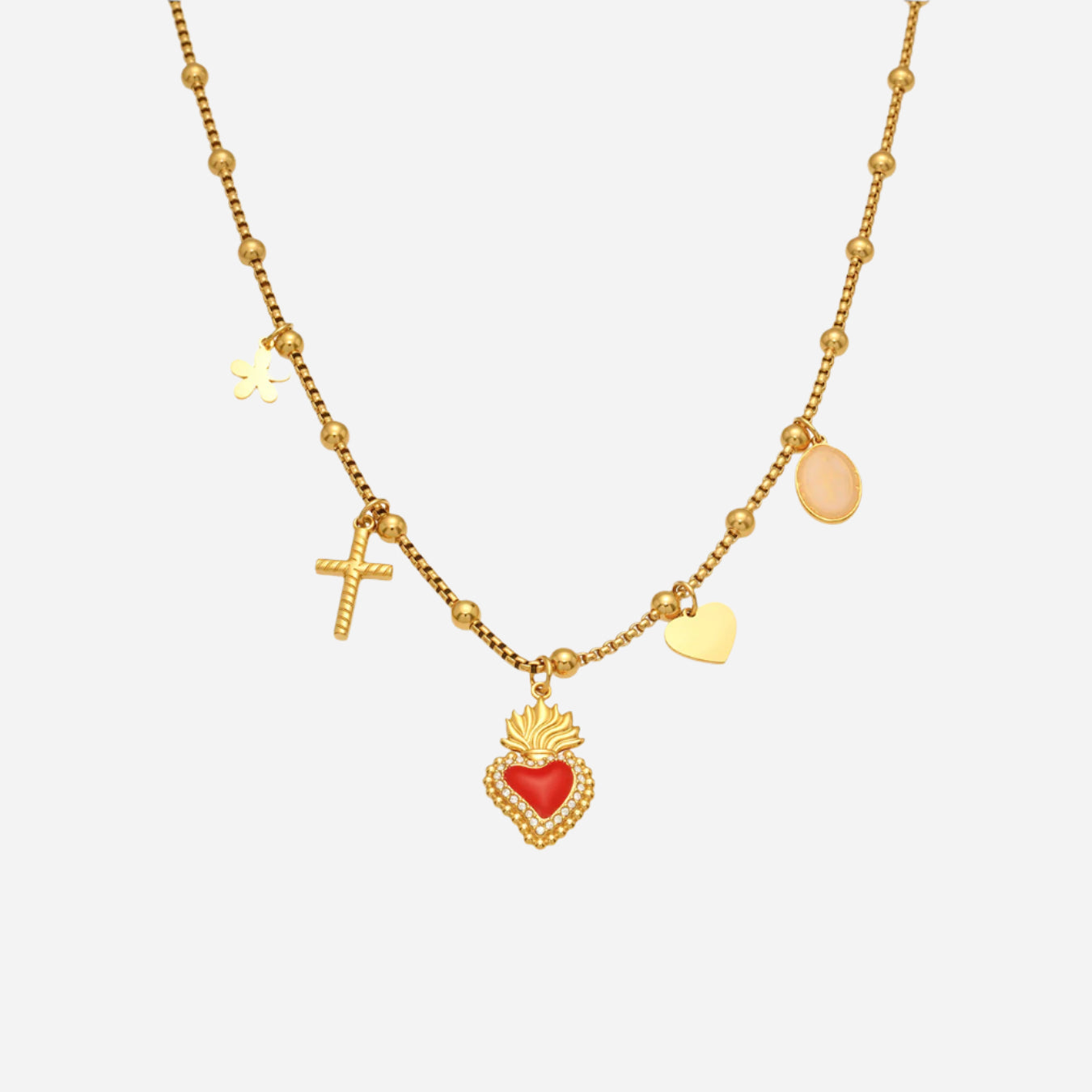 Gold necklace with heart, cross, and round pendants on a white background