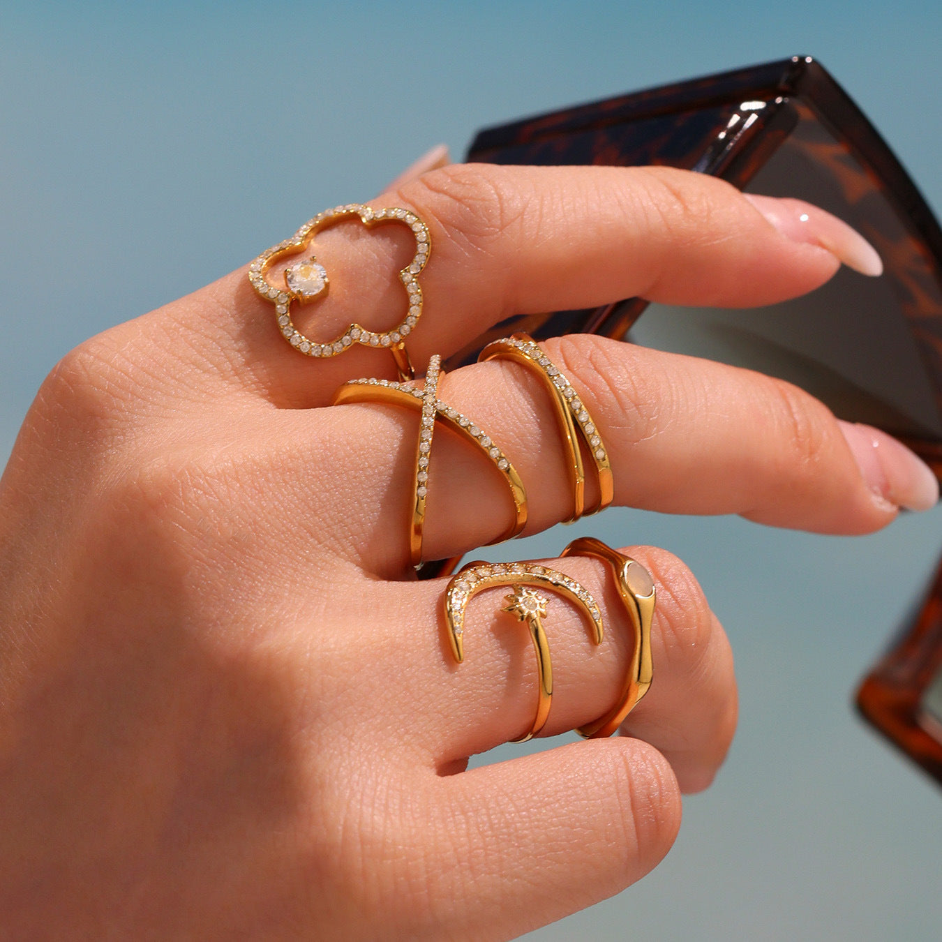 Hand styling gold and pearl rings under natural sunlight for a chic jewelry look