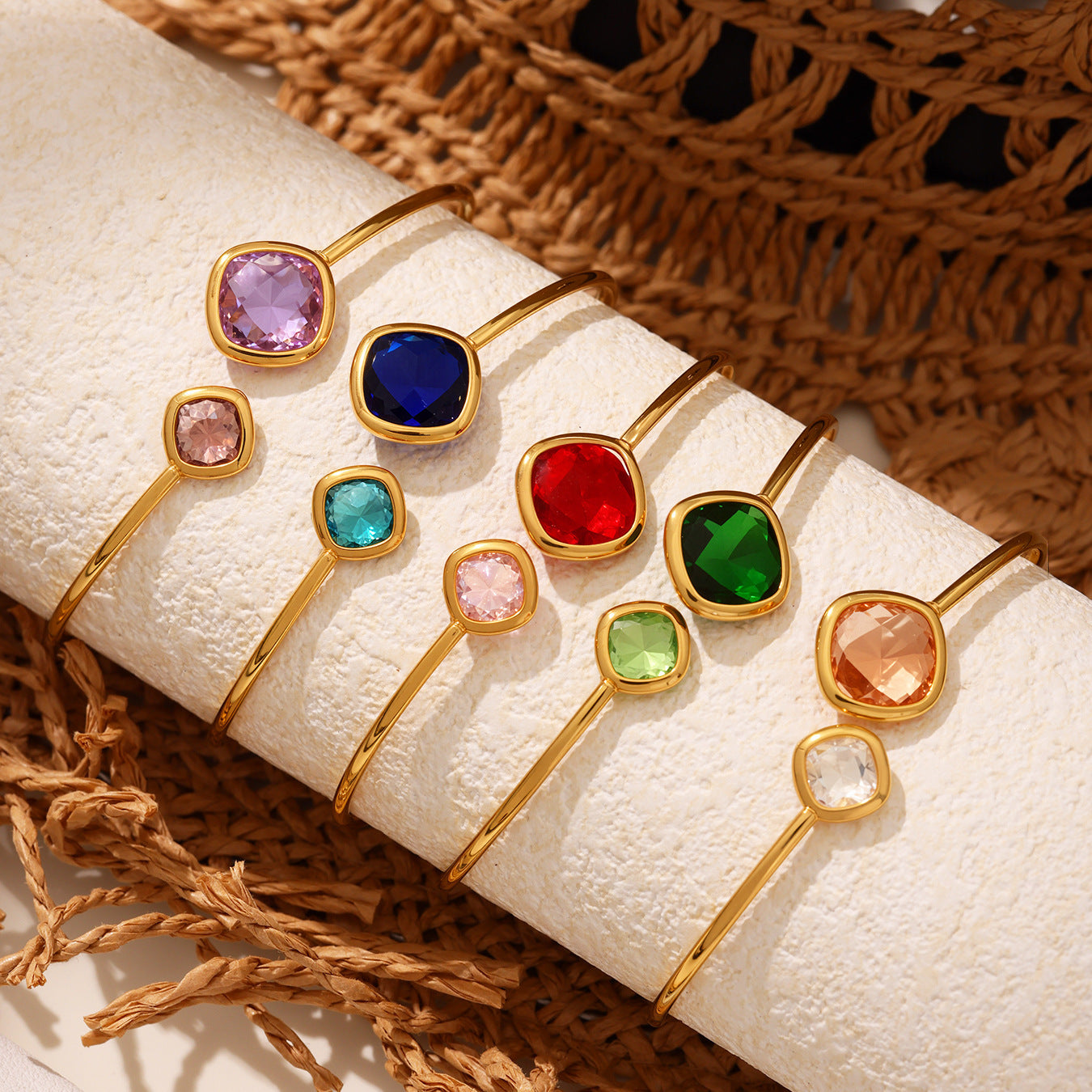 Gold rings with colorful gemstones on a textured surface