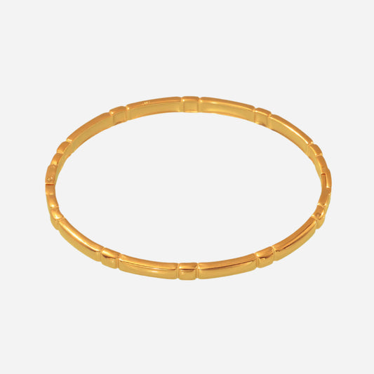 A gold tone cuff bracelet with a minimalist design, crafted from stainless steel with an 18K gold tone plating.