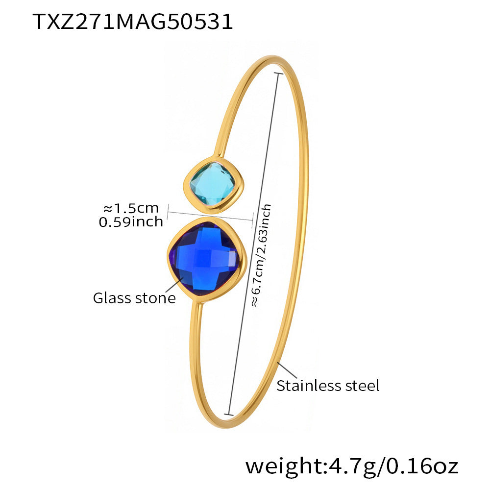 Gold bracelet with blue glass stones and measurements on a white background