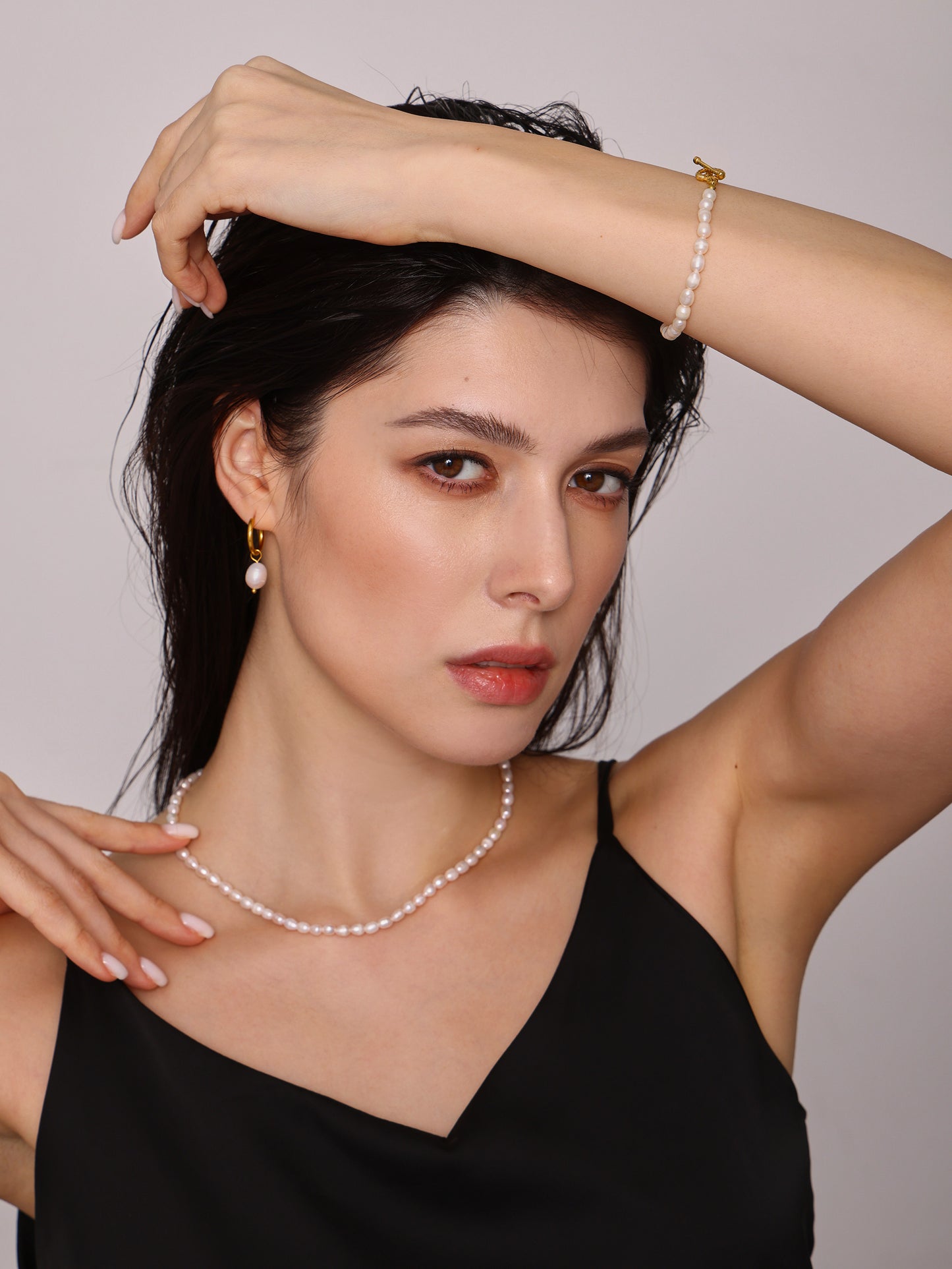 Model wearing pearl bracelet styled for evening with soft lighting
