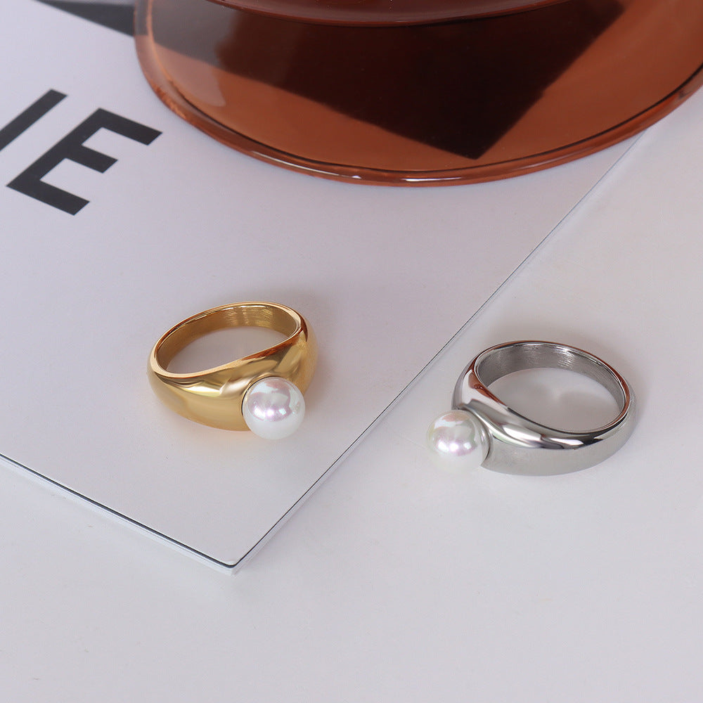 Gold and silver pearl rings side by side on reflective surface – adjustable and tarnish-free