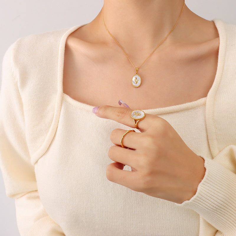 Adjustable gold ring with white seashell inlay, copper base, labeled on white background