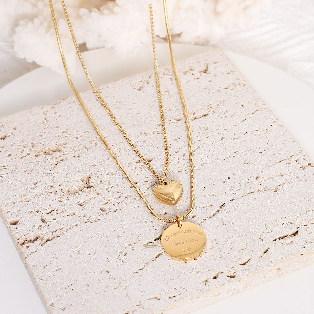 Gold peach heart double layered necklace shot in warm lighting – ideal romantic stainless steel jewelry for gifting