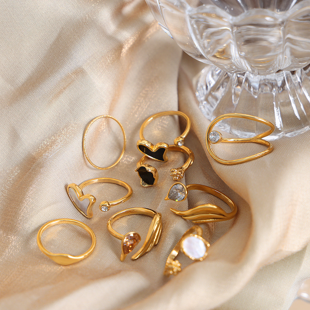 Gold rings with heart designs on a beige fabric background