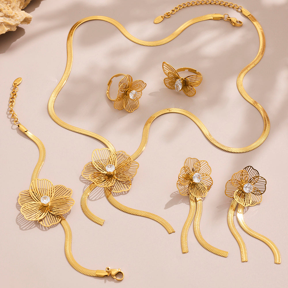 Gold jewelry set with necklace, bracelet, and earrings on a beige background