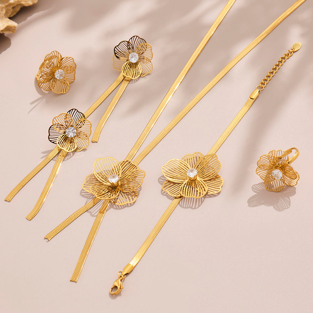 Gold floral jewelry set on a beige background