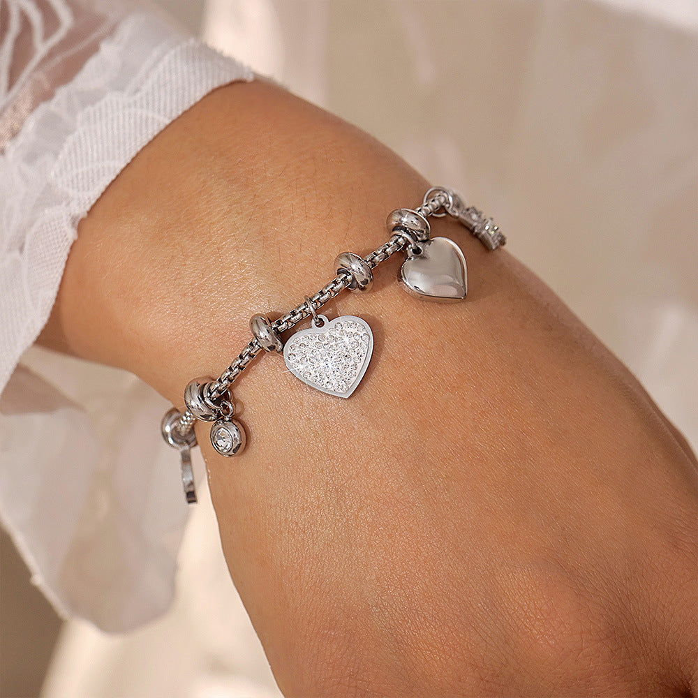 Silver stainless steel heart tennis bracelet with CZ studs shown on wrist – hypoallergenic & tarnish-free
