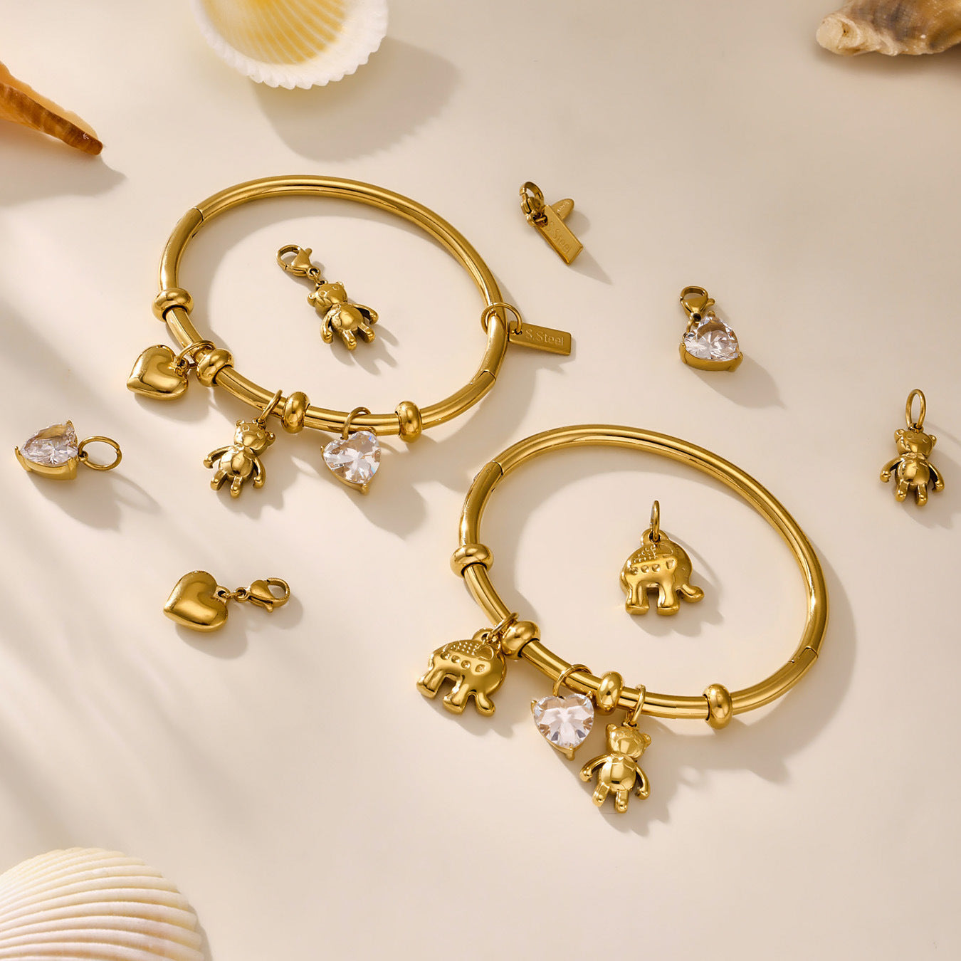 Gold stainless steel bracelet and charm jewelry set on a beige background