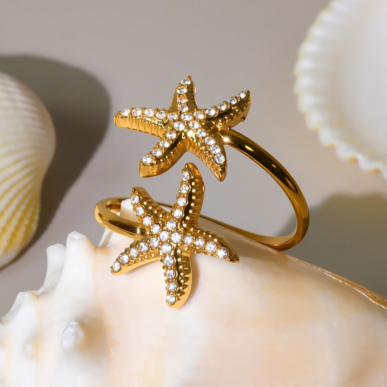 18K gold starfish star ring placed on seashell background, ocean inspired cubic zirconia jewelry