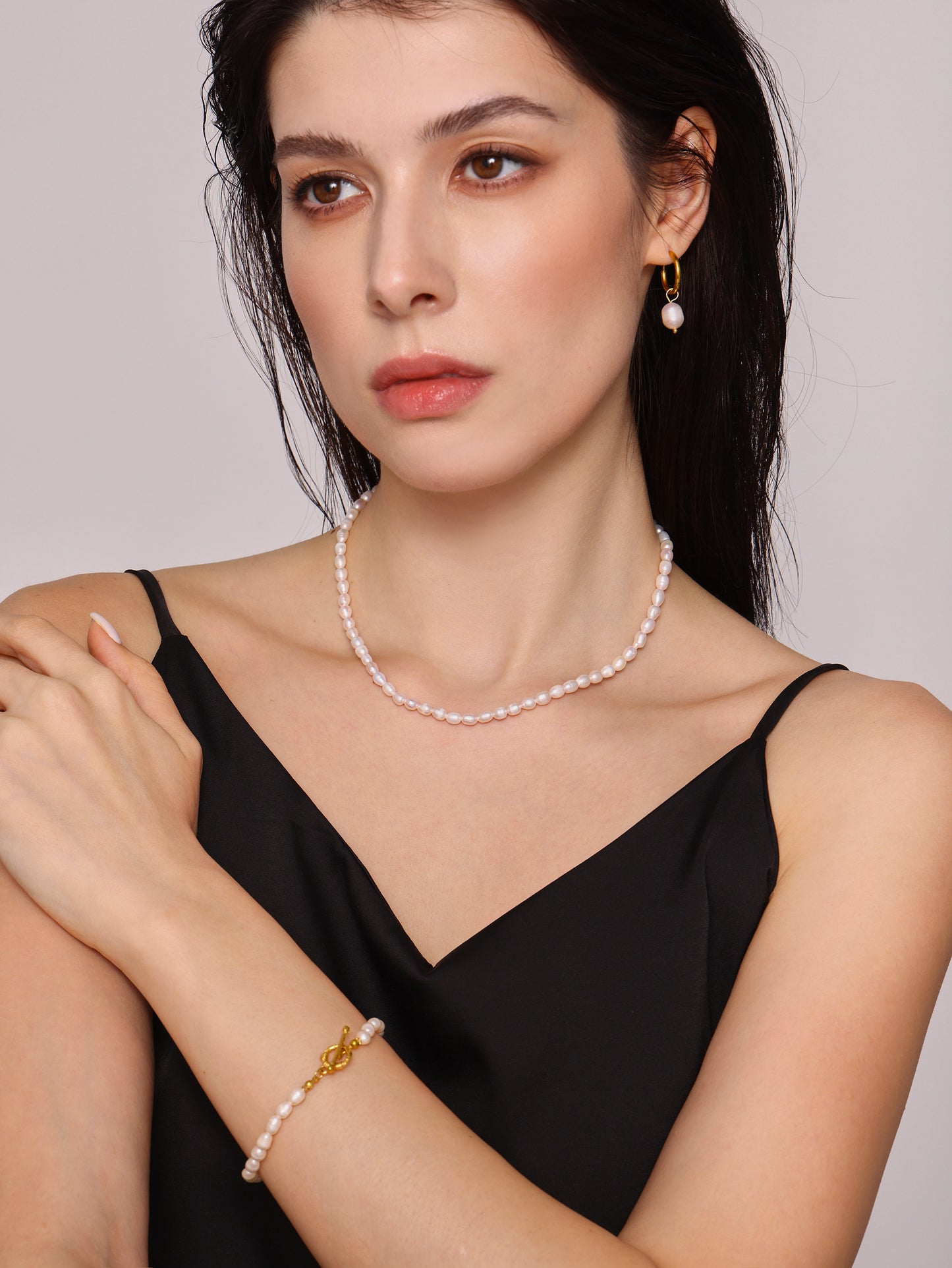 Model styling T-bar pearl bracelet with modern minimalist clothing