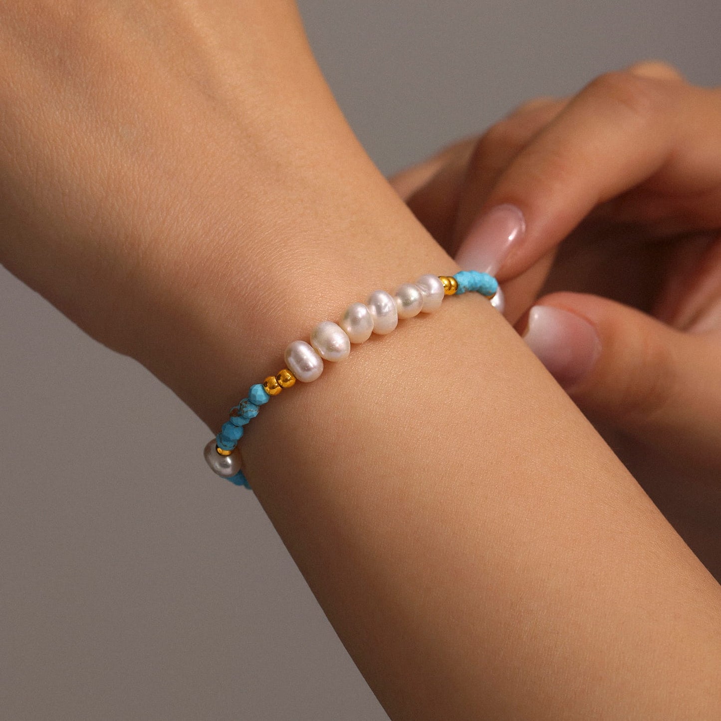 Woman wearing turquoise and pearl bracelet with casual summer outfit
