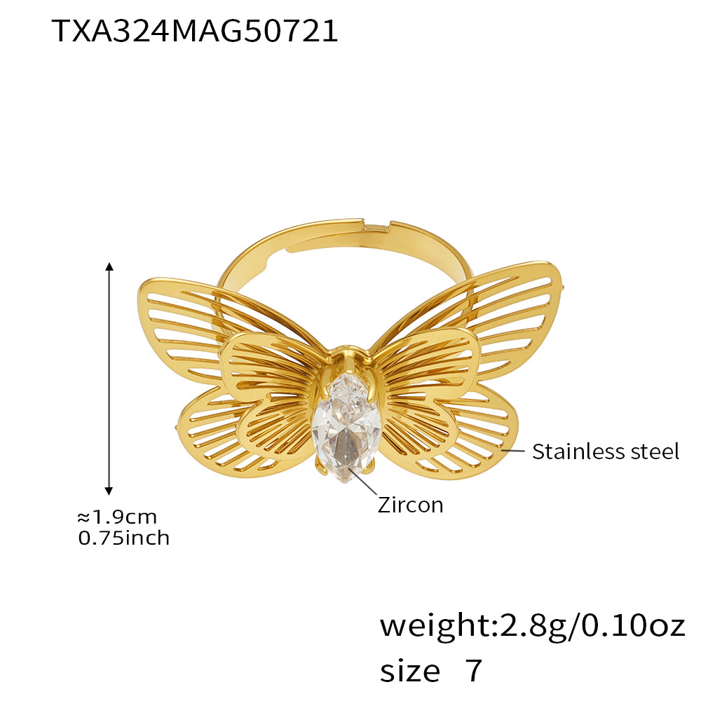 Gold butterfly-shaped ring with zircon on a white background