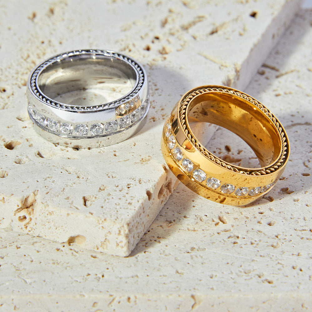 Gold and silver open rings on textured beige background – modern stackable stainless steel jewelry